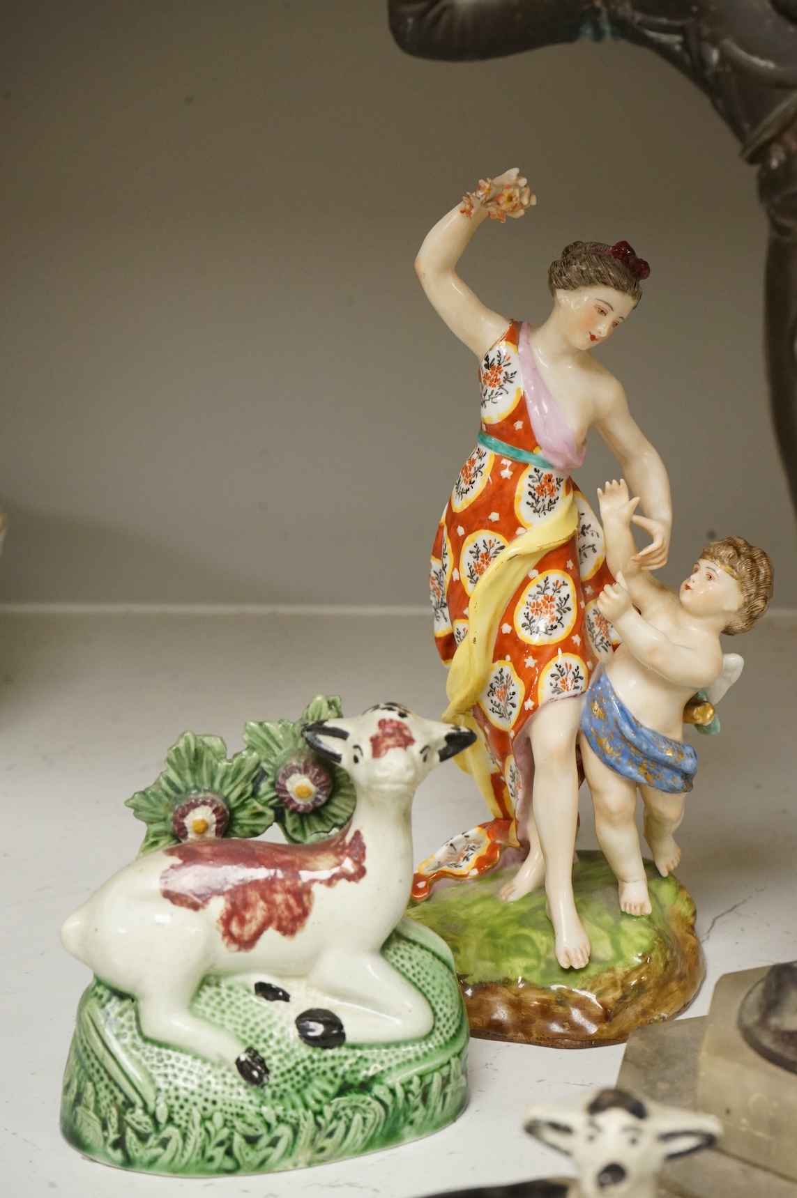 An Art Deco resin and patinated spelter model of a dancer on onyx base, two late 18th century Staffordshire coloured creamware recumbent cows and a spongeware deer, a WWI commemorative teapot with ‘For Right and Freedom’